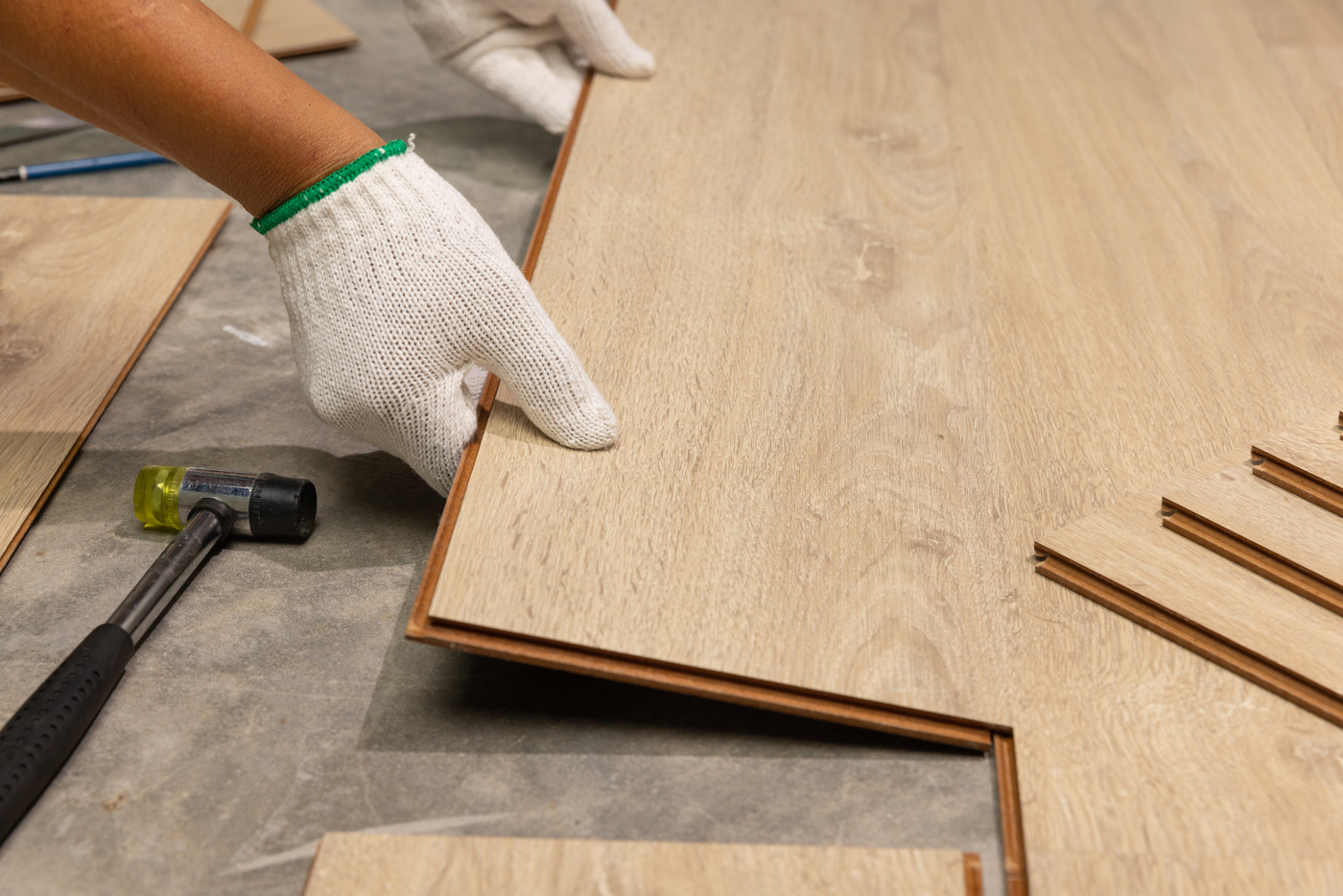 Worker Installing Interlocking laminate floor, home renovation.